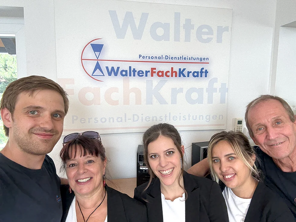 5 fröhliche Gesichter schauen in die Kamera.